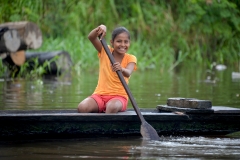 Kid-paddling-dugout-canoe-in-Iquitos-Peru